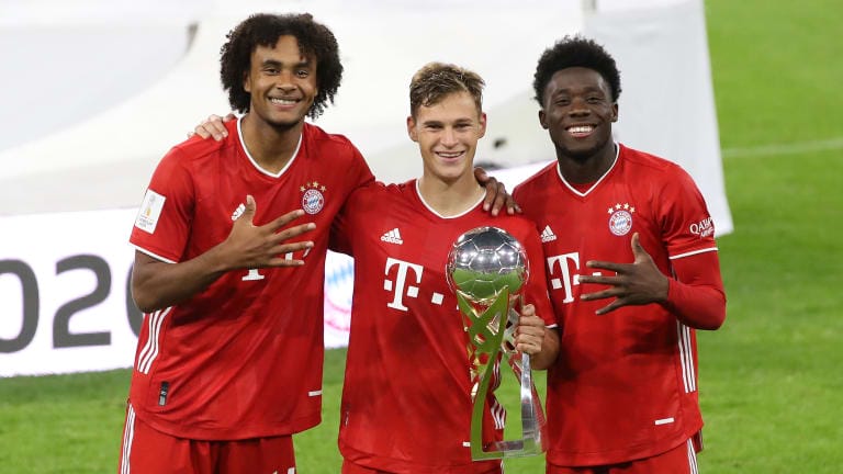 (L-R) Joshua Zirkzee, Joshua Kimmich and Alphonos Davies of FC Bayern München celebrate with the Supercup trophy
