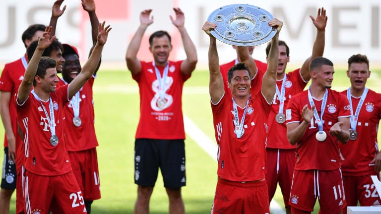 Robert Lewandowski of FC Bayern Muenchen lifts the trophy to celebrate the championship following the Bundesliga match between VfL Wolfsburg and FC Bayern Muenchen