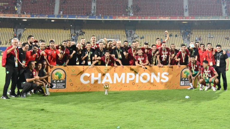 Members of team Morocco pose for photos with the trophy