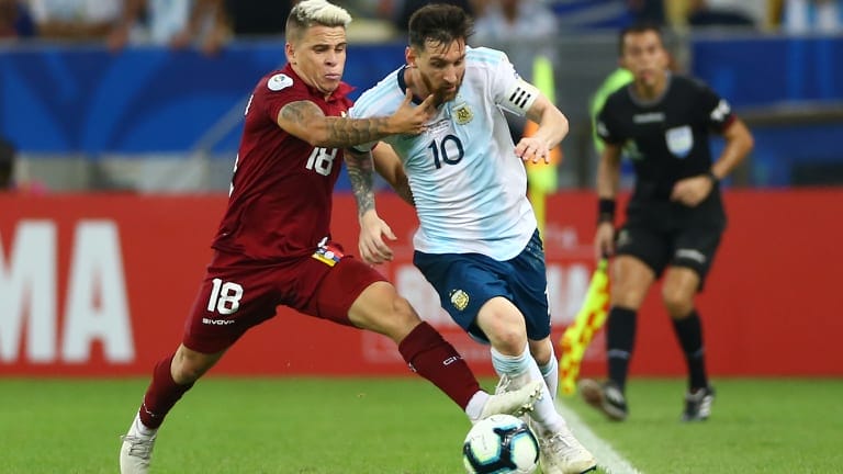 Lionel Messi of Argentina fights for the ball with Yeferson Soteldo