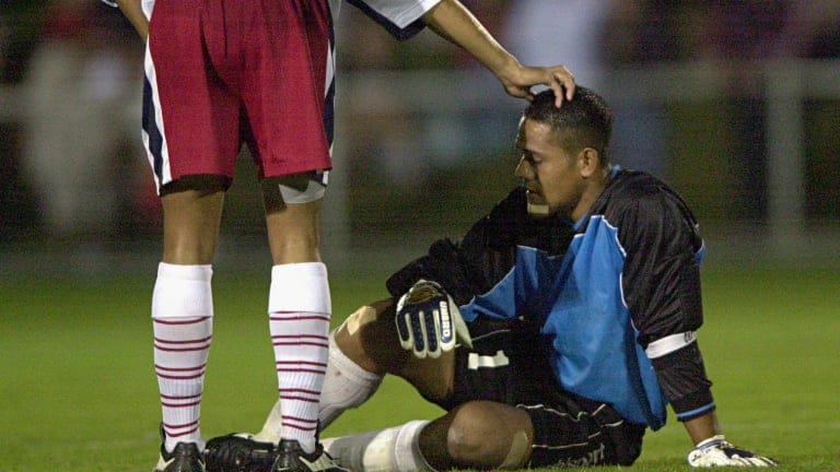 Nicky Salapu #1 of American Samoa is comforted by team mate Young Im Min #20 after they were beaten 31 to nil by Australia