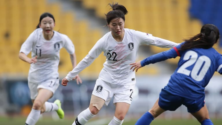 Korea Republic forward Kang Chaerim (M) dribbles past a defender