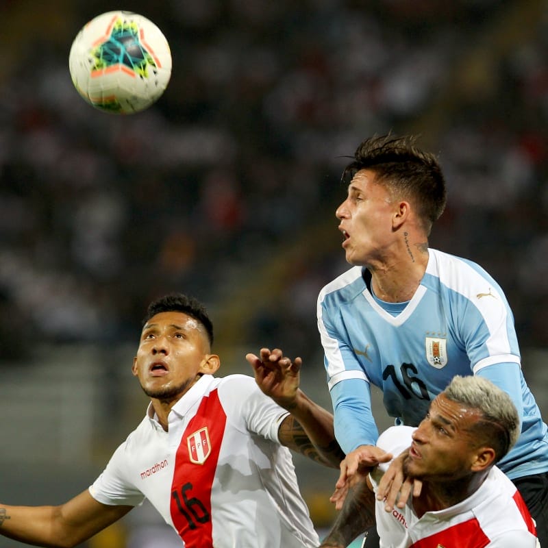 Christofer Gonzales and Miguel Trauco of Peru struggle for the ball with Brian Rodriguez of Uruguay
