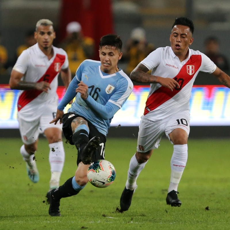 Uruguay s Brian Rodriguez (C) and Peru s Christian Cueva (R) fight for the ball&nbsp;