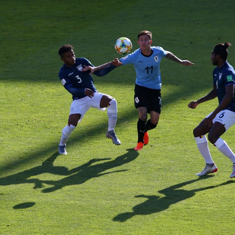 Brian Rodriguez of Uruguay battles for possession with Diego Palacios and Exon Vallecilla of Ecuador