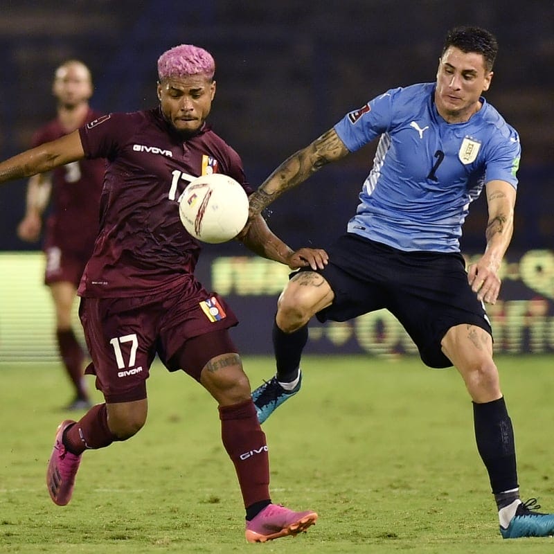 Josef Martínez of Venezuela fights for the ball with José Giménez of Uruguay