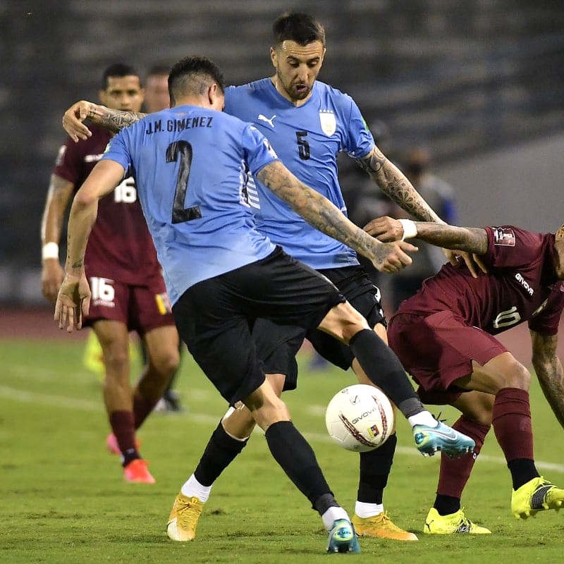 Rómulo Otero of Venezuela fights for the ball with Matí­as Vecino and José Giménez of Uruguay