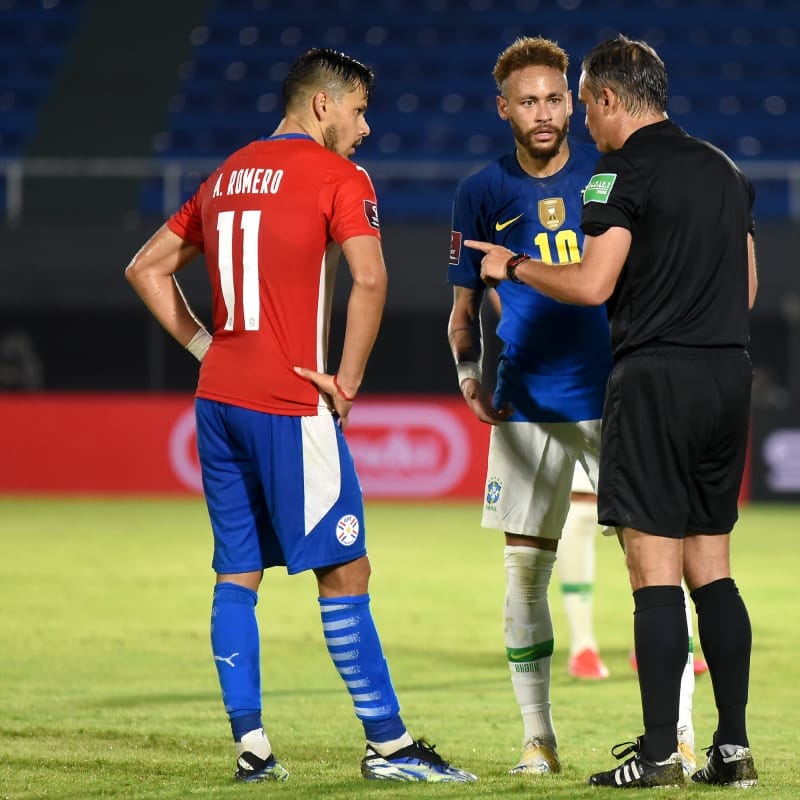 Referee Patricio Loustau argues with Ángel Romero of Paraguay and Neymar of Brazil