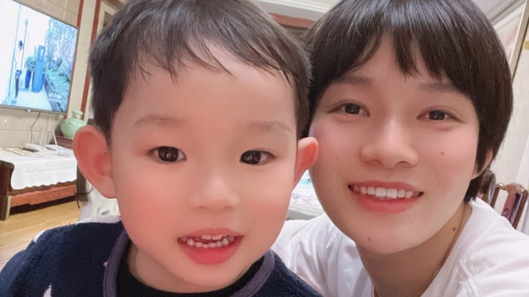 China women team midfielder Zhang Xin poses for a photo with her son