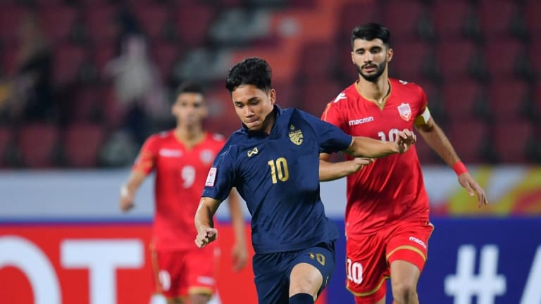 Thailand's Supachok Sarachat (M) plays the ball forward