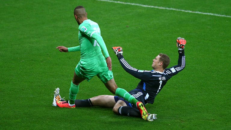 Goalkeeper Manuel Neuer of Germany tackles Islam Slimani of Algeria