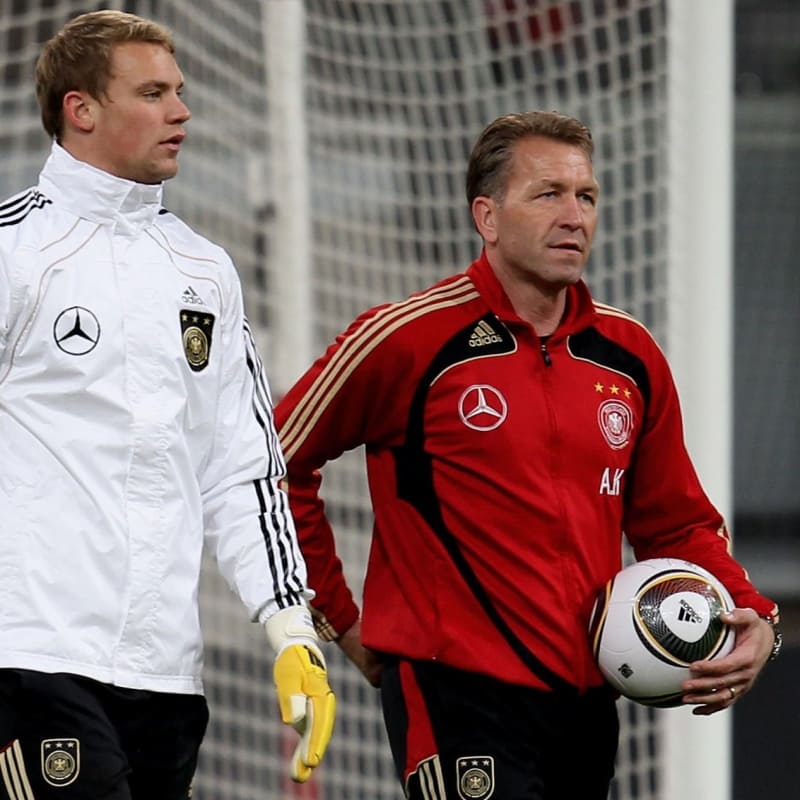 Goalkeeper Manuel Neuer and coach Andreas Koepke walk over the pitch