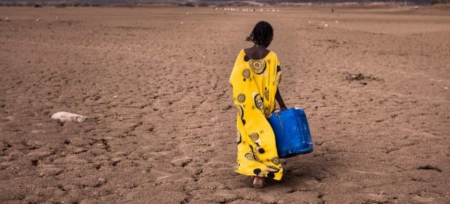 A girl walks with a water container in the Afar region in Ethiopia. A girl walks with a water container in the Afar region in Ethiopia.