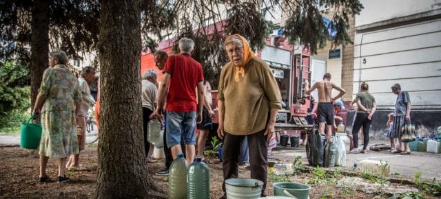 A woman collects water from a truck in Lysychanskt, Ukraine. A woman collects water from a truck in Lysychanskt, Ukraine.