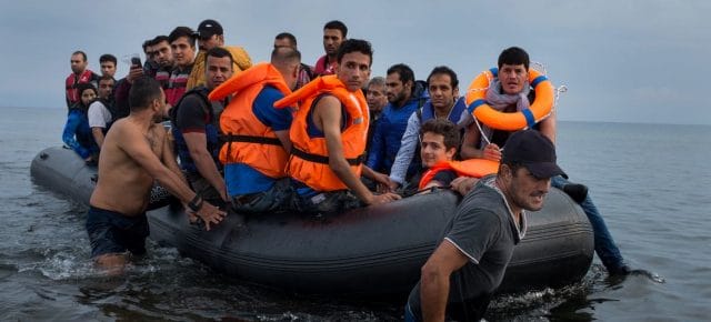 A large rubber boat filled with refugees is pulled to shore on the island of Lesbos, in the North Aegean region. (file) A large rubber boat filled with refugees is pulled to shore on the island of Lesbos, in the North Aegean region. (file)