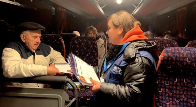 Ukrainians travelling to Romania receiving practical information, food and blankets from IOM staff. Ukrainians travelling to Romania receiving practical information, food and blankets from IOM staff.