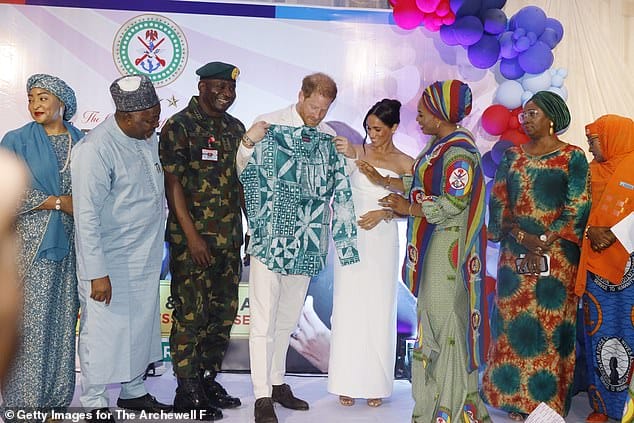 Prince Harry is gifted a shirt during the ceremony in Abuja, Nigeria