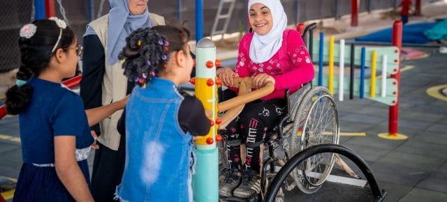 A nine-year-old child plays seesaw with her friends in an inclusive playground at her school in the Za’atari refugee camp in Jordan.